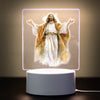 A 3D LED night light depicting Jesus Christ with outstretched arms, illuminated against a soft background.