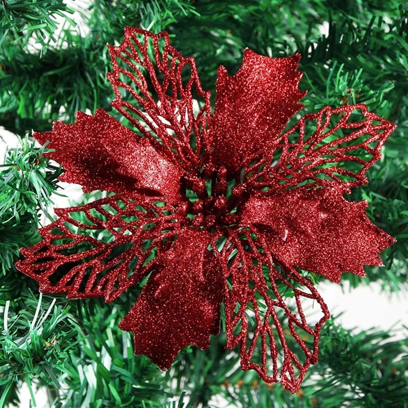 Red glittery silk artificial Christmas flowers with gold sparkle finish on a green pine branch