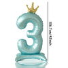 A large, light blue foil number balloon shaped like the number three with a gold crown topper.