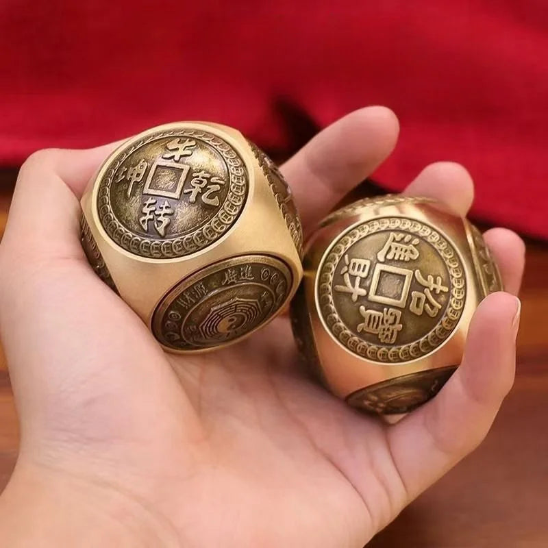 A hand holds two antique-style Chinese lucky coins, featuring traditional characters and a square design, against a red backg