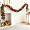 An artificial red berry holly Christmas garland draped across a white fireplace mantel.