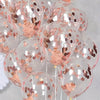 A collection of clear balloons filled with pink liquid and decorated with rose gold sequins for party decor.