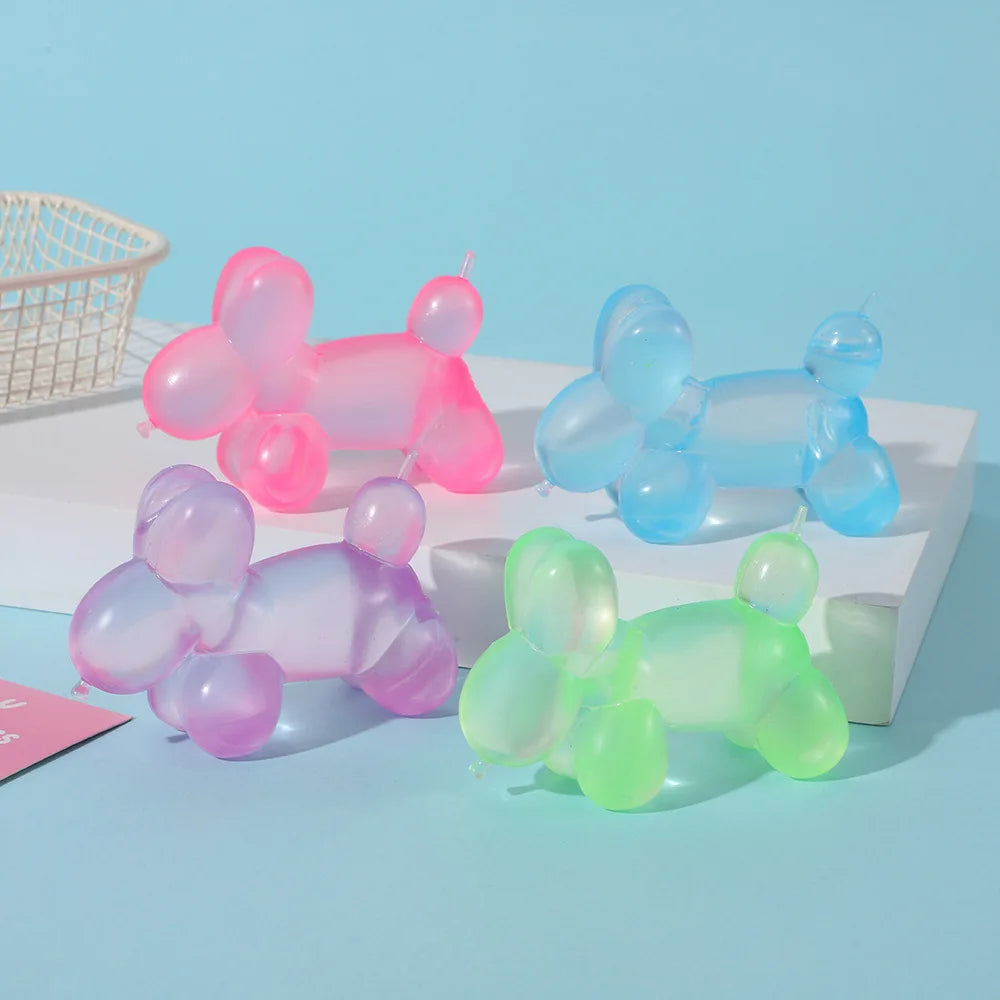 A collection of various colored squishy stress relief toys, including pink, purple, and green balloons, displayed on a white 