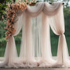 Elegant pink tulle backdrop featuring draped fabric and floral accents for events