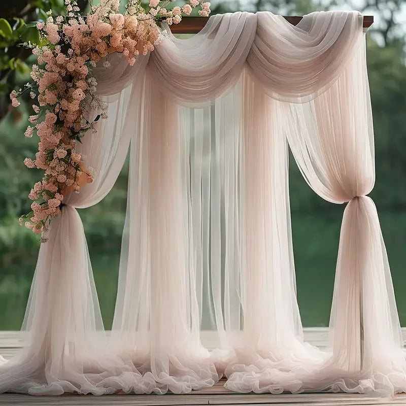 Elegant pink tulle backdrop featuring draped fabric and floral accents for events