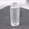 Clear glass miniature dollhouse vase and wine bottle set with a stopper, shown against a dark surface.