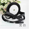 Black silk satin ribbon shown against a white background with pink flowers.