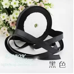 Black silk satin ribbon shown against a white background with pink flowers.