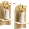 Two pairs of dried ornamental grasses in white ceramic vases displayed on wooden wall shelves