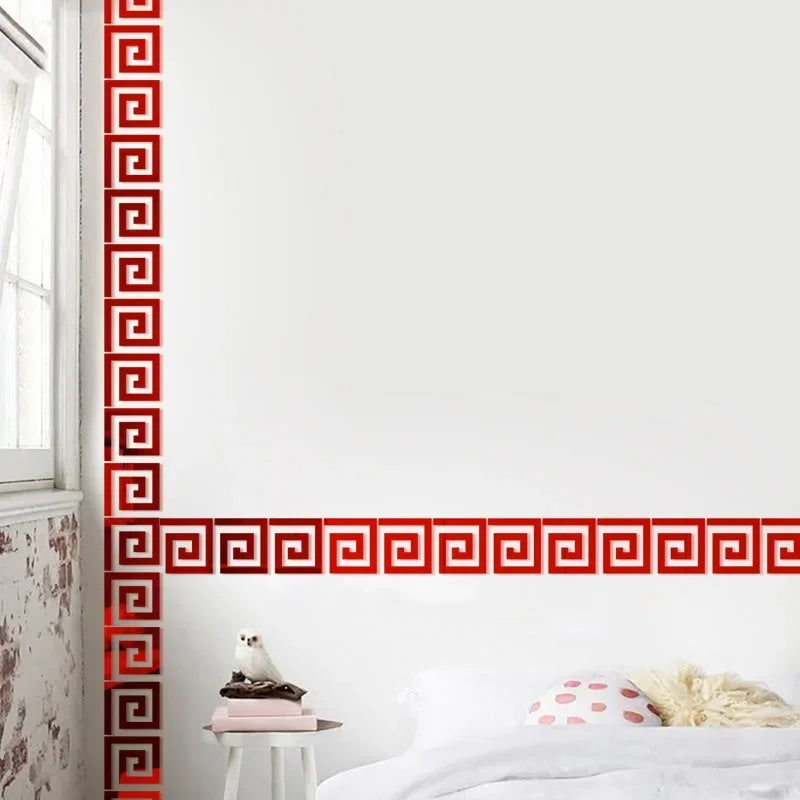 A white wall with a vertical red geometric pattern and a horizontal red geometric border above a bed.