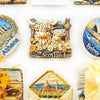 A collection of fridge magnets featuring Scottish Highland cows, Athens, and Sydney.