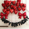 A garland of black heart balloons spelling out HAPPY BIRTHDAY against a white wall.