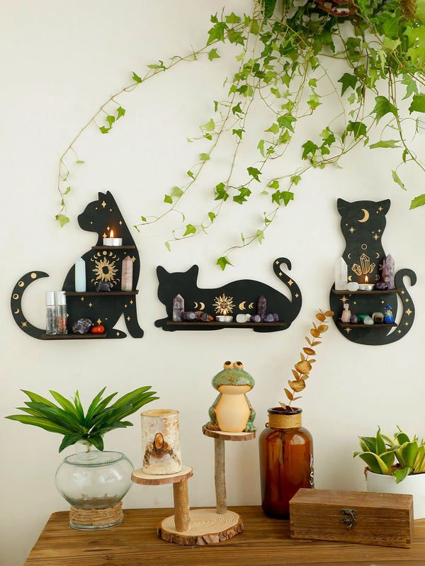 A black cat moon phase floating shelf displaying crystals and decor on a white wall.
