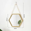 A gold-framed hexagon decorative wall mirror hanging by a chain.