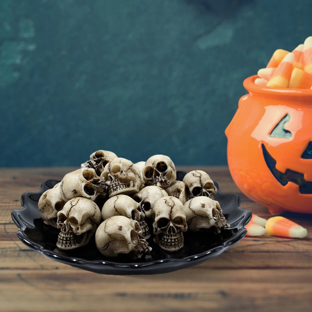 A pile of realistic skull figurines displayed on a black plate with a pumpkin-orange background.