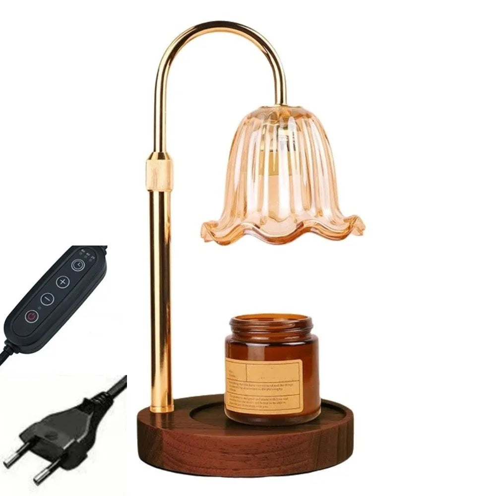 A brass adjustable height aromatherapy candle warmer lamp with a glass shade and a wooden base.