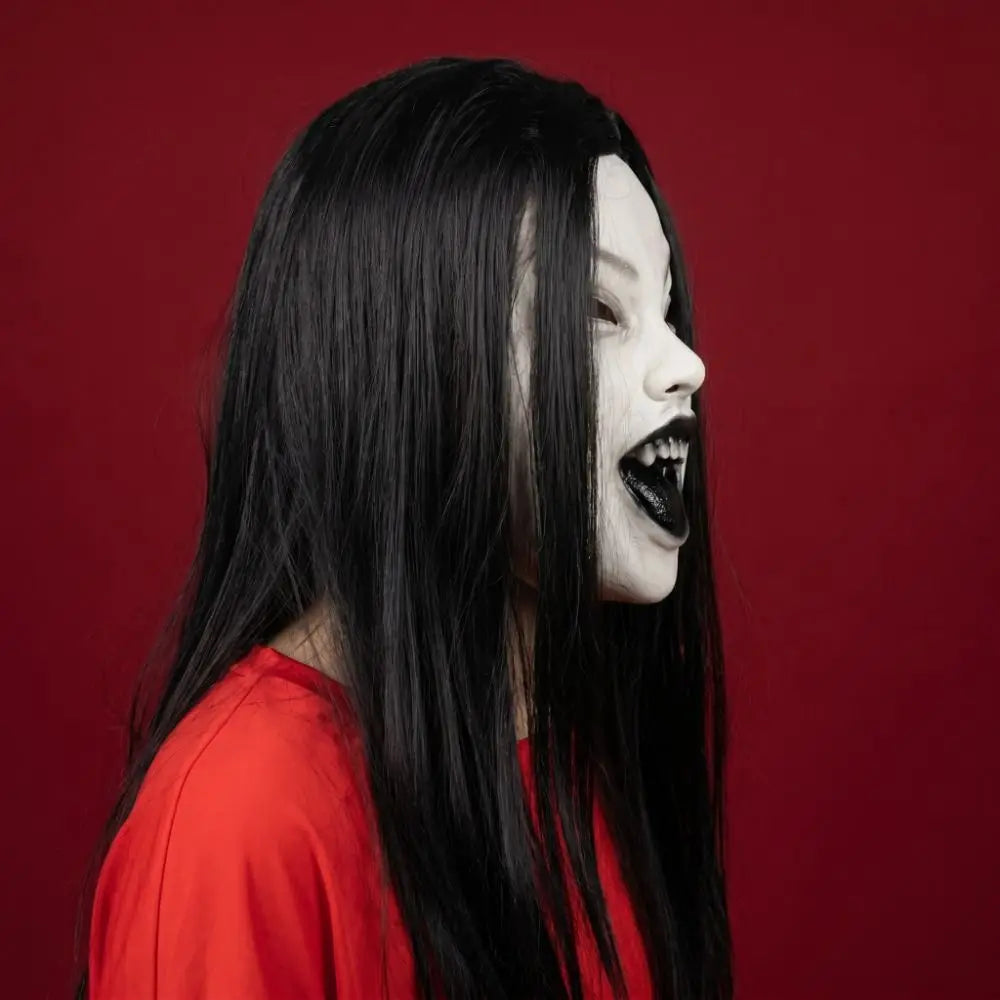 A woman with long black hair and dark makeup is shown in profile against a red background.