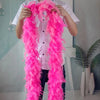A person is holding a bright pink natural turkey feather boa for costumes and crafts.