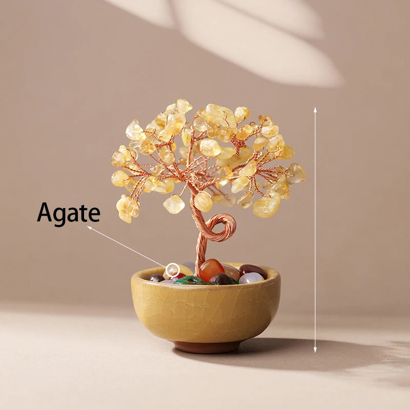 A handcrafted agate crystal tree with a copper wire base sits in a bowl on a neutral background.