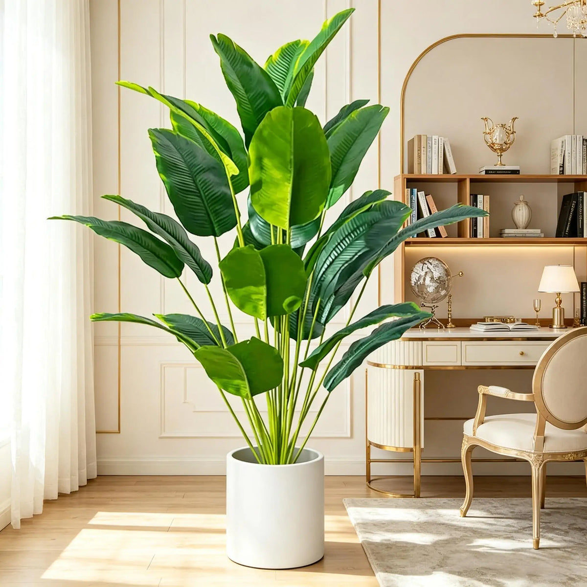 A large artificial Bird of Paradise plant in a white pot sits on a wooden table next to a chair.