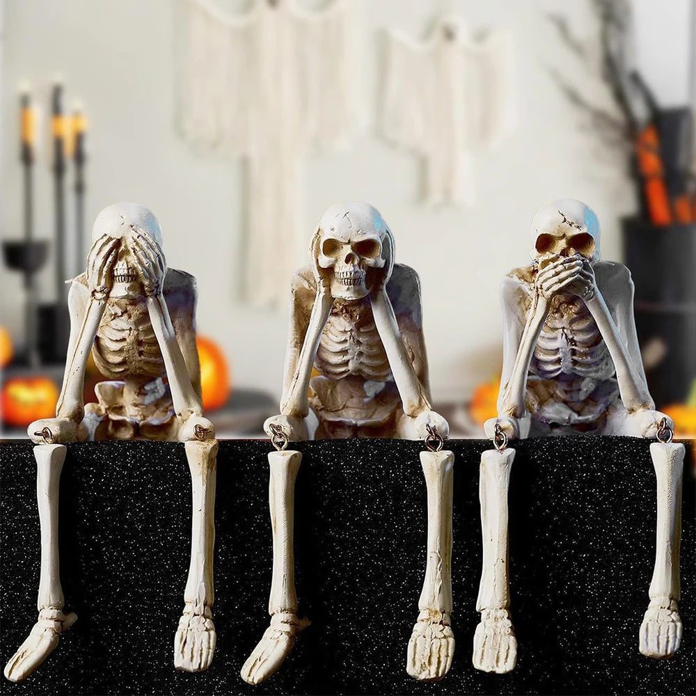 A set of three skull figurines depicting hands covering faces, used for a See No Evil Hear No Evil Speak No Evil theme.