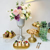 Elegant gold cylinder flower vases with mixed floral arrangements on a white tablecloth.