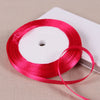 A roll of bright pink satin ribbon on a white spool resting on a light beige surface.