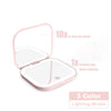 A pink portable folding makeup mirror with an LED light, showing options for 1x and 10x magnification.