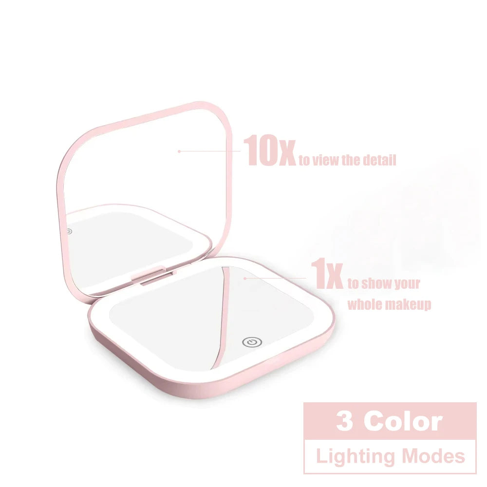 A pink portable folding makeup mirror with an LED light, showing options for 1x and 10x magnification.