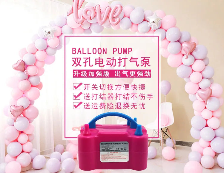 A pink electric balloon pump is displayed in front of a heart-shaped balloon arch decorated with pink and white balloons.