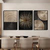 A set of three abstract canvas prints featuring concentric circle patterns in gold and black tones displayed on a light wall.
