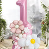 A pink pillar balloon set shaped like the number one decorated with white and pink floral balloons in a bright, airy setting.
