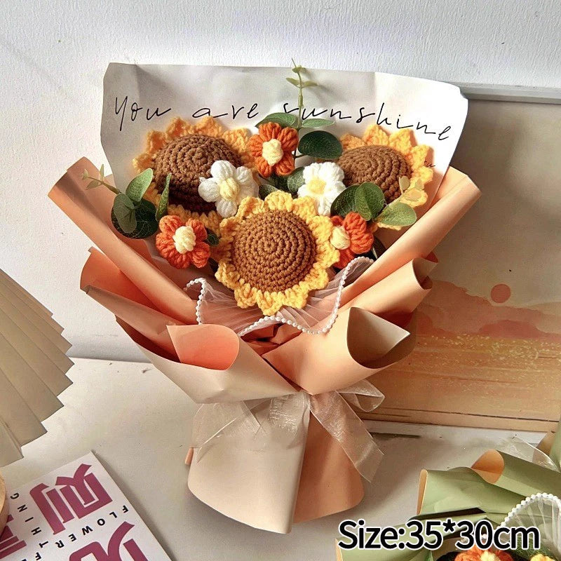 A bouquet of handmade crochet flowers in shades of orange, yellow, and white arranged in brown paper.