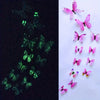 A collection of twelve luminous pink and purple butterfly wall stickers on a white background.