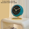 A teal desktop alarm clock with a gold rim and black face showing the time.