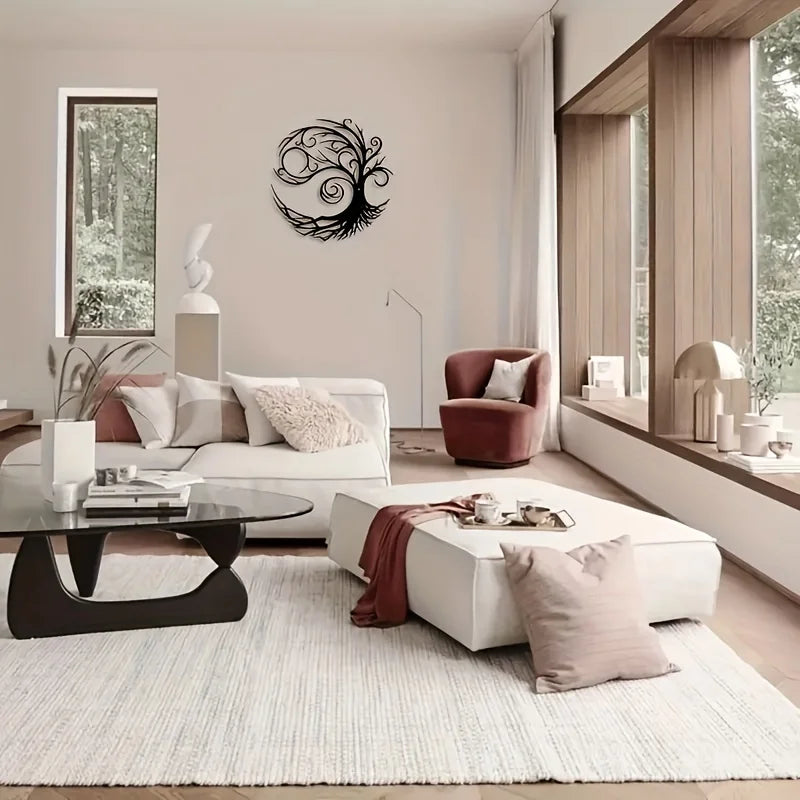 A modern living room featuring a white sofa, light wood floor, and a black metal tree of life wall art.