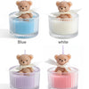 Four soy wax teddy bear candles in glass jars featuring blue, white, purple, and pink colors with ribbons