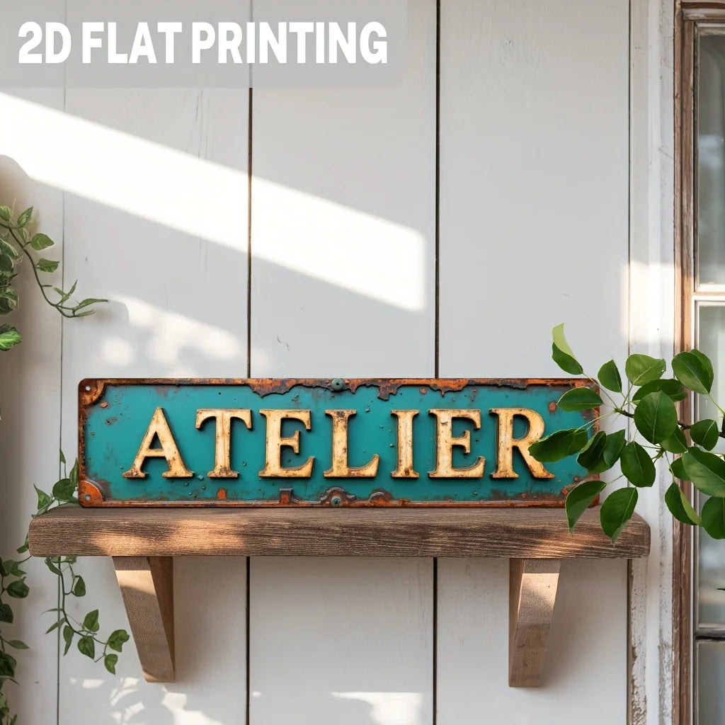 A vintage industrial metal wall sign with the word ATELIER in golden lettering on a turquoise distressed background.