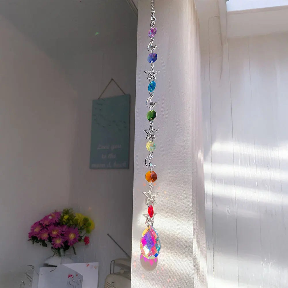 A silver crystal wind chime pendant featuring a rainbow of colored crystals hanging on a white wall.