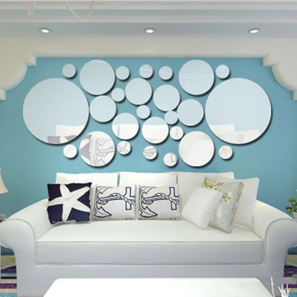 A light blue wall decorated with a cluster of round mirrors and a white sofa.
