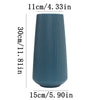 A tall, ribbed, matte blue ceramic flower vase shown from the side.