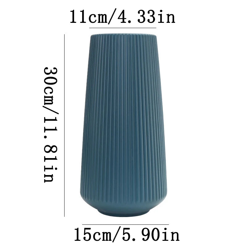 A tall, ribbed, matte blue ceramic flower vase shown from the side.