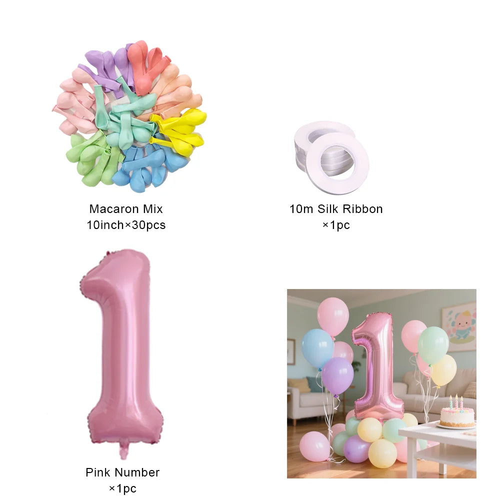 Un ensemble de ballons en papier alu roses en forme du chiffre un et de macarons de différentes couleurs.