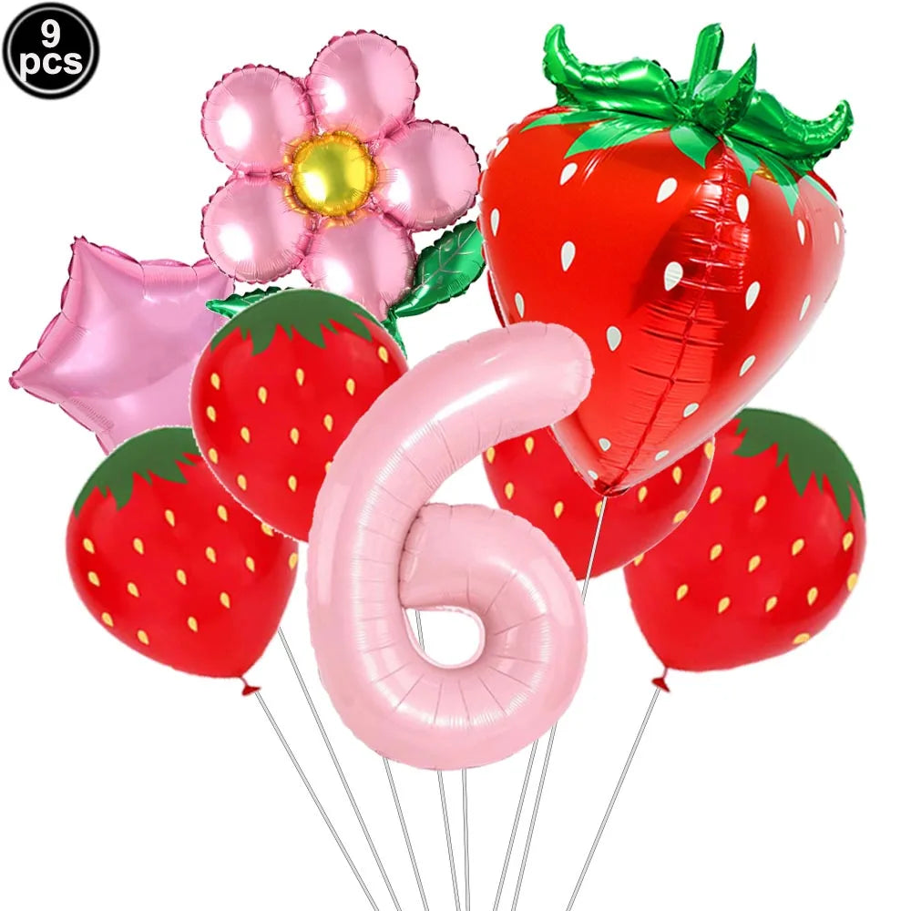 A set of pink and red strawberry balloons, including a flower balloon and a large number six balloon.