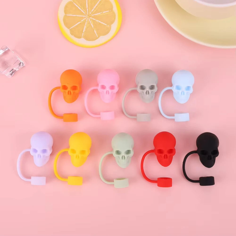 A collection of reusable silicone straw covers shaped like skulls in various colors including orange, pink, gray, blue, yello