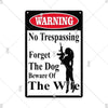 A vintage red and black warning sign with the text WARNING No Trespassing Forget The Dog Beware Of The Wife