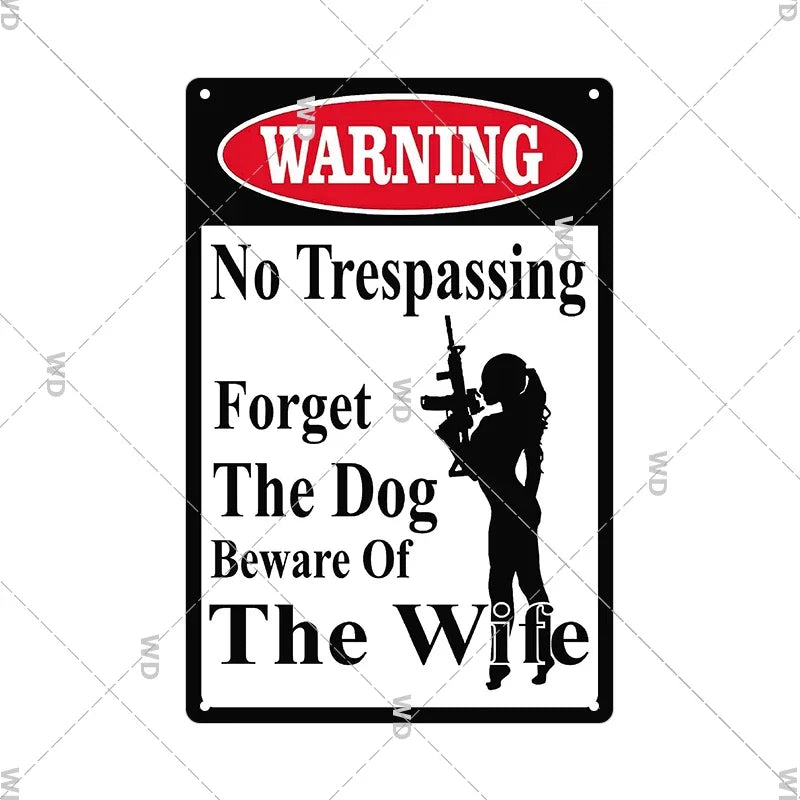 A vintage red and black warning sign with the text WARNING No Trespassing Forget The Dog Beware Of The Wife