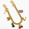 Collier en chaîne doré avec un charm de fleur violette et feuille verte.