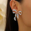 Gold-toned bow stud earrings featuring blue and white porcelain design
