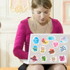 A young woman is looking down at a laptop displaying various inspirational quotes and affirmations on a pink background.